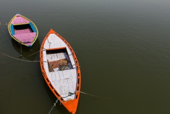 Met dit soort roeibootjes maken de toeristen een tochtje over de Ganges.