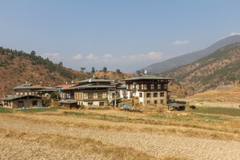 Op weg naar de tempel lopen we langs typische huizen in Bhutan, groot genoeg voor de hele familie.